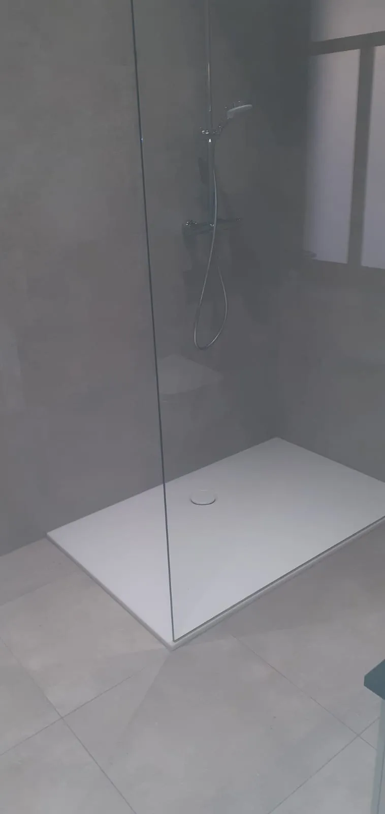 Bodengleiche Dusche mit rahmenloser Glasabtrennung und grauen Großformatfliesen