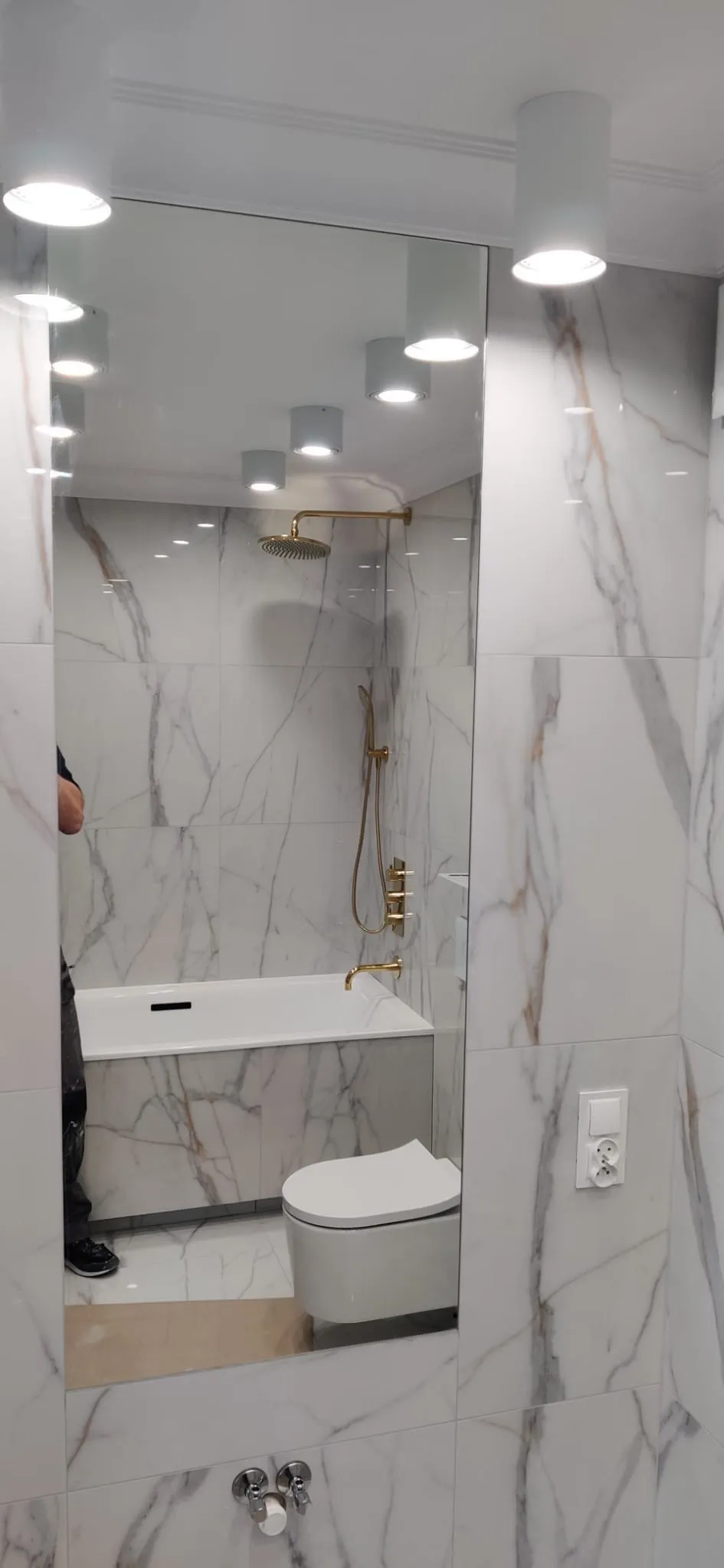 Wandbündiger Spiegel im Marmorbad mit Blick auf Wanne und Wand-WC